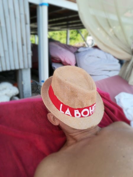 Sieste avec chapeau sur le visage dans un lit a baldaquin sur la plage de la Bohemia Beach Lounge a Koh Samui