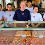 Pizza MakMak est une pizzeria de rue proposant des carrés de pizzas à la coupe et au poids à Koh Samui, en Thaïlande.